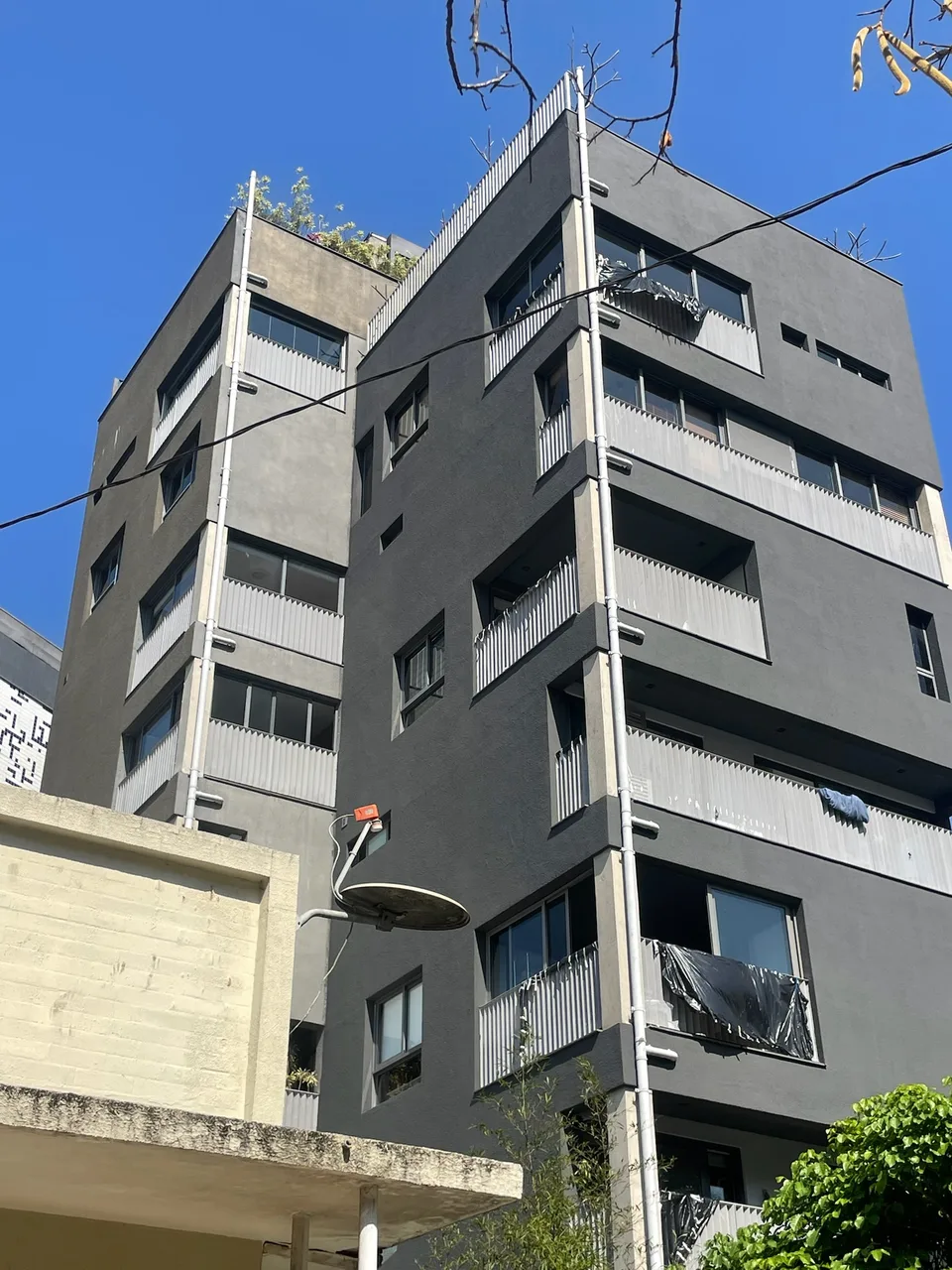 Fachada predial renovada com acabamento cinza